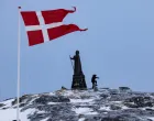 FILE PHOTO: A man walks as Danish flag flutters next to Hans Egede Statue ahead of a March 11 general election in Nuuk, Greenland, March 9, 2025. REUTERS/Marko Djurica/File Photo/Marko Djurica