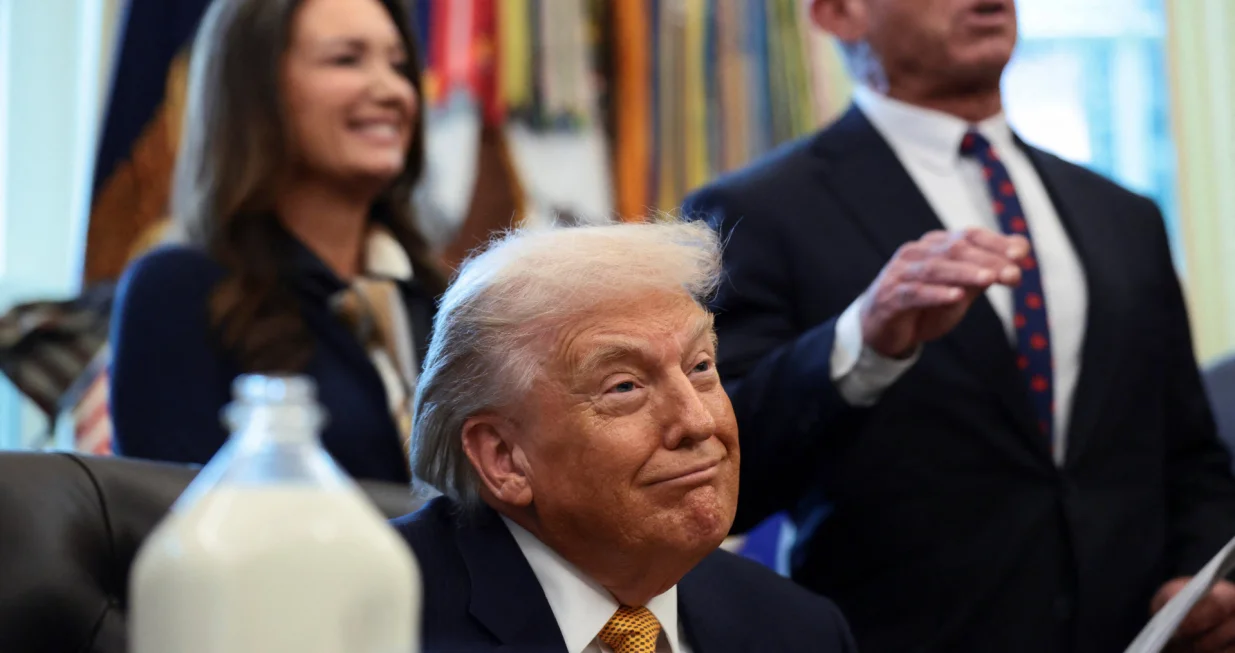 U.S. President Donald Trump listens as U.S. Health and Human Services (HHS) Secretary Robert F. Kennedy Jr. speaks during the signing ceremony for the Whole Milk for Healthy Kids Act in the Oval Office at the White House in Washington, D.C., U.S., January 14, 2026. REUTERS/Evelyn Hockstein/Evelyn Hockstein