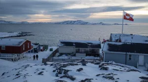 A Greenland flag flies as people walk on the day of a meeting between top U.S. officials and the foreign ministers of Denmark and Greenland, in Nuuk, Greenland, January 14, 2026. REUTERS/Marko Djurica/Marko Djurica