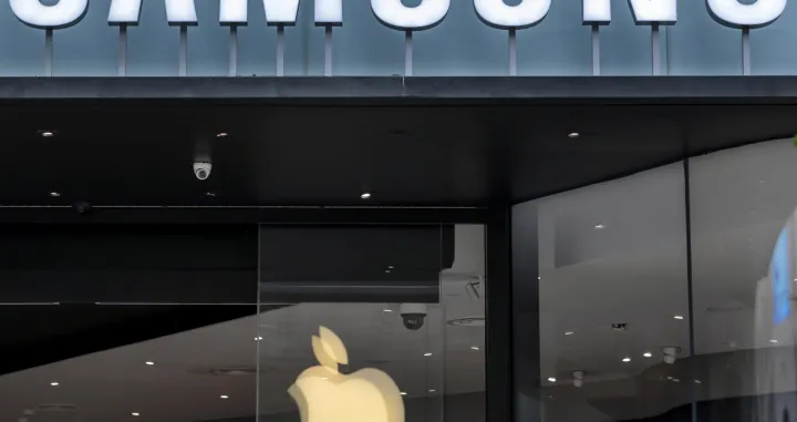 epa08544846 Apple logo is seen reflected on a Samsung store window in Shanghai, China, 14 July 2020. The World Health Organization (WHO) has confirmed the deployment of an epidemiologist and an animal diseases specialist in an effort to trace the origin of the virus. EPA/ALEX PLAVEVSKI/Alex Plavevski