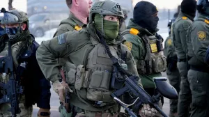A member of the Special Response Team (SRT) holds his weapons at a protest against the fatal shooting of Renee Nicole Good by a U.S. Immigration and Customs Enforcement (ICE) agent, during a rally against increased immigration enforcement across the city outside the Whipple Building in Minneapolis, Minnesota, U.S., January 8, 2026. REUTERS/Tim Evans  TPX IMAGES OF THE DAY/Tim Evans