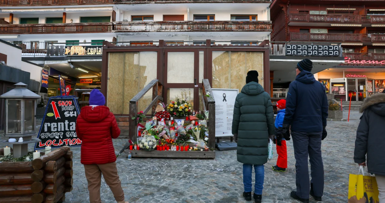 People stand by a makeshift memorial outside the "Le Constellation bar" almost a month after a deadly fire during a New Year's Eve party, in the upscale ski resort of Crans-Montana, Switzerland, January 31, 2026. REUTERS/Denis Balibouse/Denis Balibouse