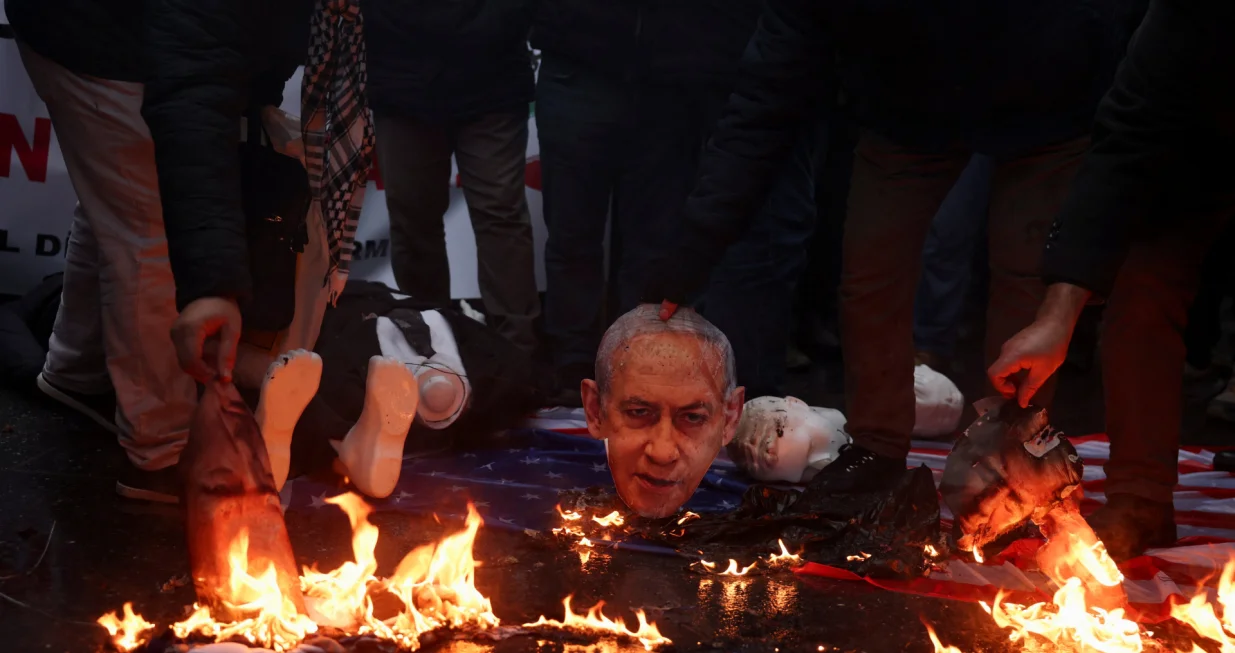 Demonstrators set fire to cutouts depicting Israeli Prime Minister Benjamin Netanyahu and U.S. President Donald Trump during a rally in solidarity with Iran's government in Tehran, near the Iranian Consulate in Istanbul, Turkey, January 18, 2026. REUTERS/Dilara Senkaya/Dilara Senkaya