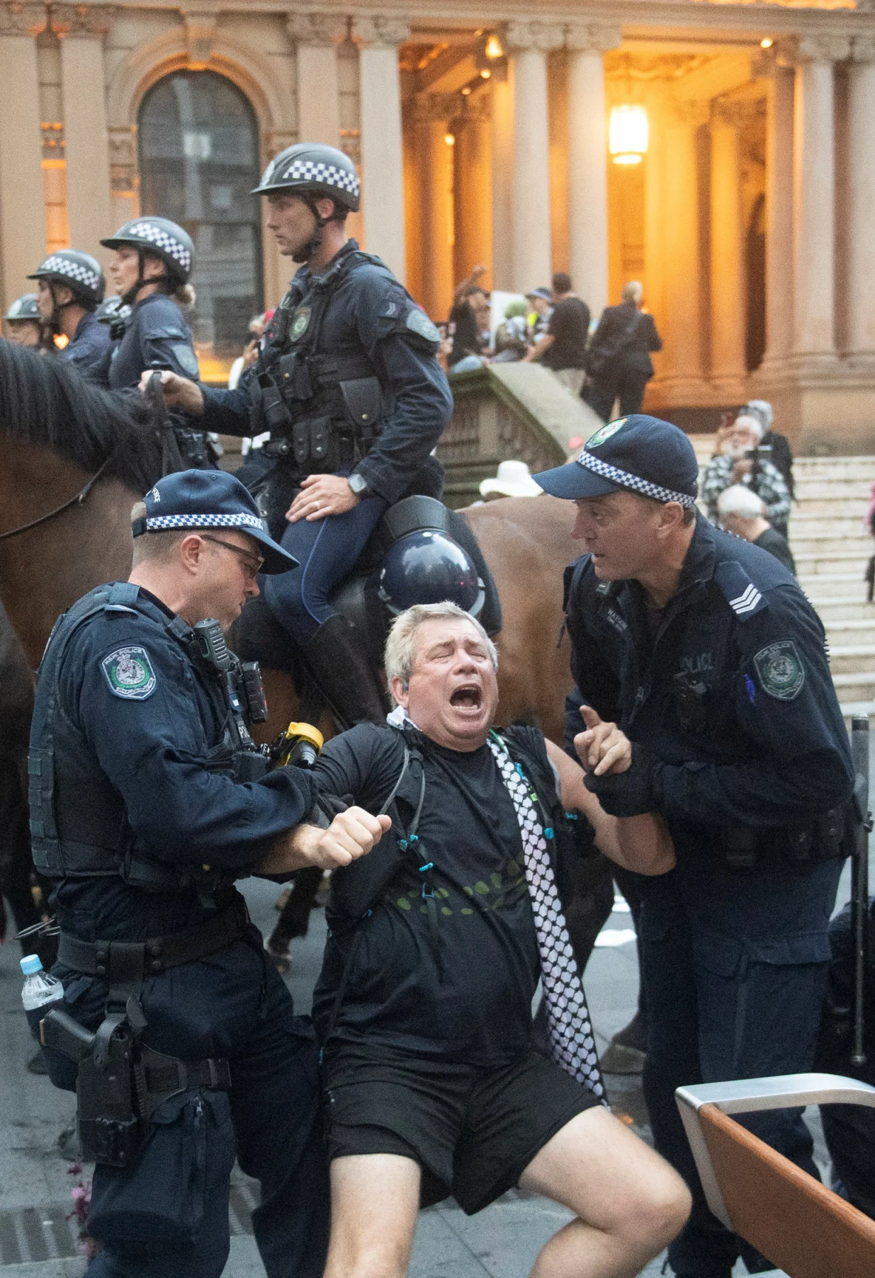 Police officers remove a protester as demonstrators gather at Town Hall Square to protest against Israeli President Isaac Herzog's state visit to Australia following a deadly mass shooting during a Jewish Hanukkah celebration at Bondi Beach on December 14, in Sydney, Australia, February 9, 2026. REUTERS/Jeremy Piper/Jeremy Piper