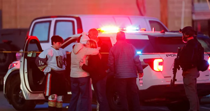 People embrace near a police officer outside the Dennis M Lynch Arena, an indoor ice skating rink, after a shooting in Pawtucket, Rhode Island, U.S., February 16, 2026. REUTERS/CJ Gunther/Cj Gunther