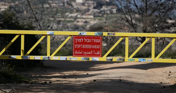 A sign is pictured on the gate from the Israeli side of the border with Lebanon, amid escalation between Hezbollah and Israel, amid the U.S.-Israeli conflict with Iran, in northern Israel, March 6, 2026. REUTERS/Ammar Awad/Ammar Awad