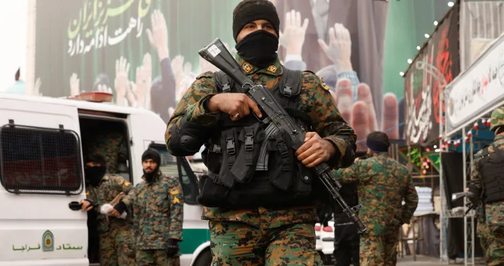 Members of the police stand guard on a street, with a large billboard featuring Iran's late Supreme Leader Ayatollah Ali Khamenei in the background, amid the U.S.-Israeli conflict with Iran, in Tehran, Iran, March 12, 2026. REUTERS/Alaa Al-Marjani/Alaa Al-marjani