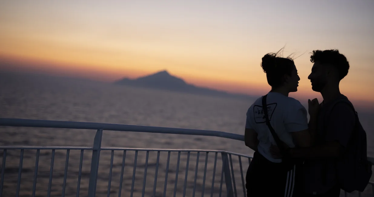 epa08615247 A couple enjoys the sunset on the deck of the ferry boat 'Nissos Mykonos', while sailing in the Aegean sea, Greece, 20 August 2020. EPA/DIMITRIS TOSIDIS/Dimitris Tosidis