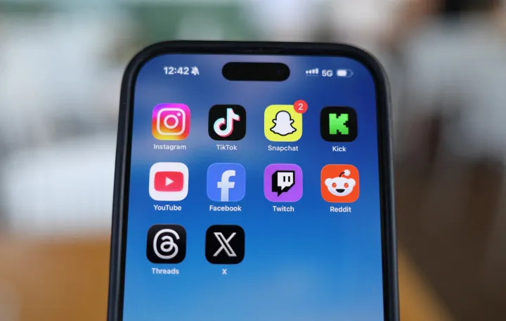 Instagram, TikTok, Snapchat, Kick, YouTube, Facebook, Twitch, Reddit, Threads and X applications are displayed on a mobile phone ahead of new law banning social media for users under 16 in Australia, in this picture illustration taken on December 9, 2025. REUTERS/Hollie Adams/Illustration/Hollie Adams